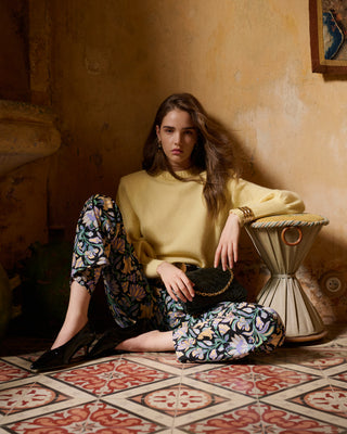 Look pull Madeleine Jaune, pantalon Petra fleuris et sac Violette tressé noir
